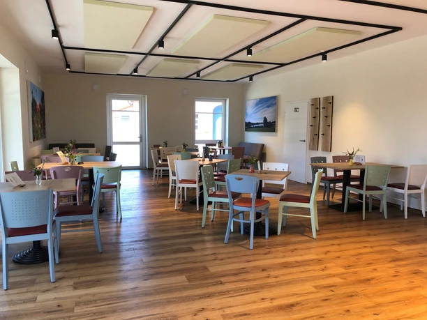 Hof Kuck Ein heller, freundlicher Raum mit modernen Holzmöbeln und Dekorationen aus frischen Blumen.