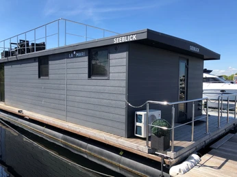 La Mare Hausboot Wieltsee Hausboot mit modernem Design und Dachterrasse auf ruhigem Gewässer unter einem klaren blauen Himmel.Houseboat with modern design and roof terrace on calm waters under a clear blue sky.Husbåd med moderne design og tagterrasse på roligt vand under en klar blå himmel.Woonboot met modern design en dakterras op kalm water onder een helderblauwe hemel.