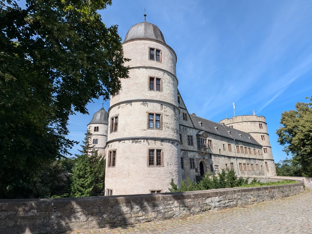 Die Wewelsburg Außenansicht Historische Renaissanceburg mit markanten Rundtürmen unter klarem Himmel, umgeben von Baumgrün.