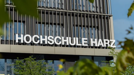 Fassade der Hochschule Harz in Wernigerode mit großem Schriftzug und grünen Blättern.