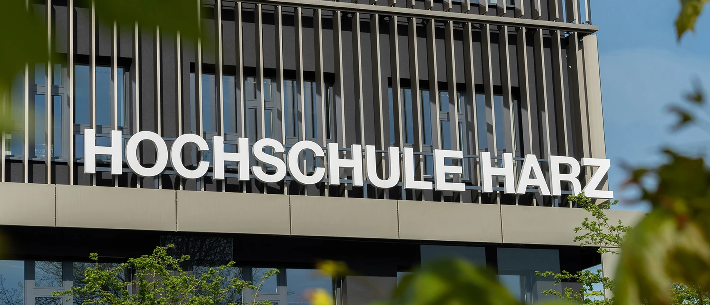 Fassade der Hochschule Harz in Wernigerode mit großem Schriftzug und grünen Blättern.