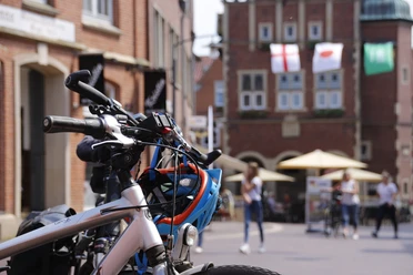 Fahrrad in Meppener Innenstadt ©Emsland Tourismus GmbH (3).jpg Fahrrad mit Helm in sonniger Innenstadt von Meppen, Passanten und historische Fassaden im Hintergrund