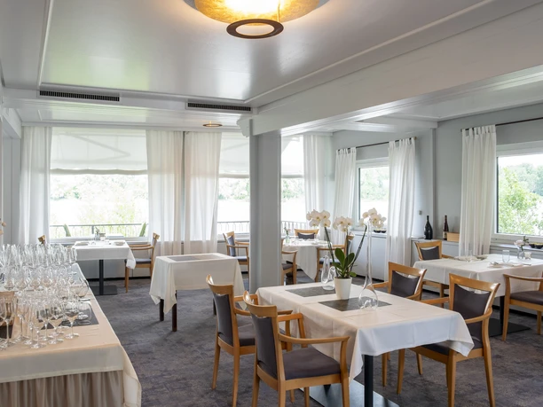 Zur Tant Elegant restaurant with stylishly set tables and large windows that let in plenty of daylight.