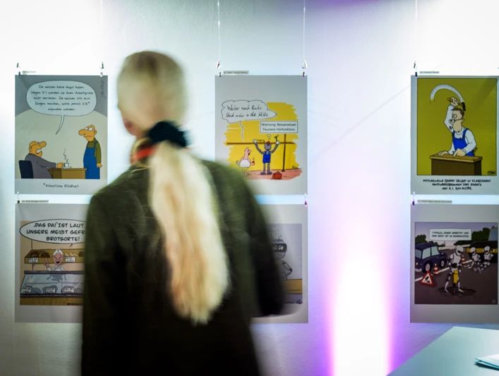 Ausstellung_2_(c)André Wirsig.jpg Person betrachtet Karikaturen in einer Galerie mit gedämpfter Beleuchtung.Person looking at caricatures in a gallery with subdued lighting.Osoba prohlížející si karikatury v galerii s tlumeným osvětlením.Osoba oglądająca karykatury w galerii przy stonowanym oświetleniu.Persoon kijkt naar karikaturen in een galerie met gedempte verlichting.Persona che guarda le caricature in una galleria con luci soffuse.
