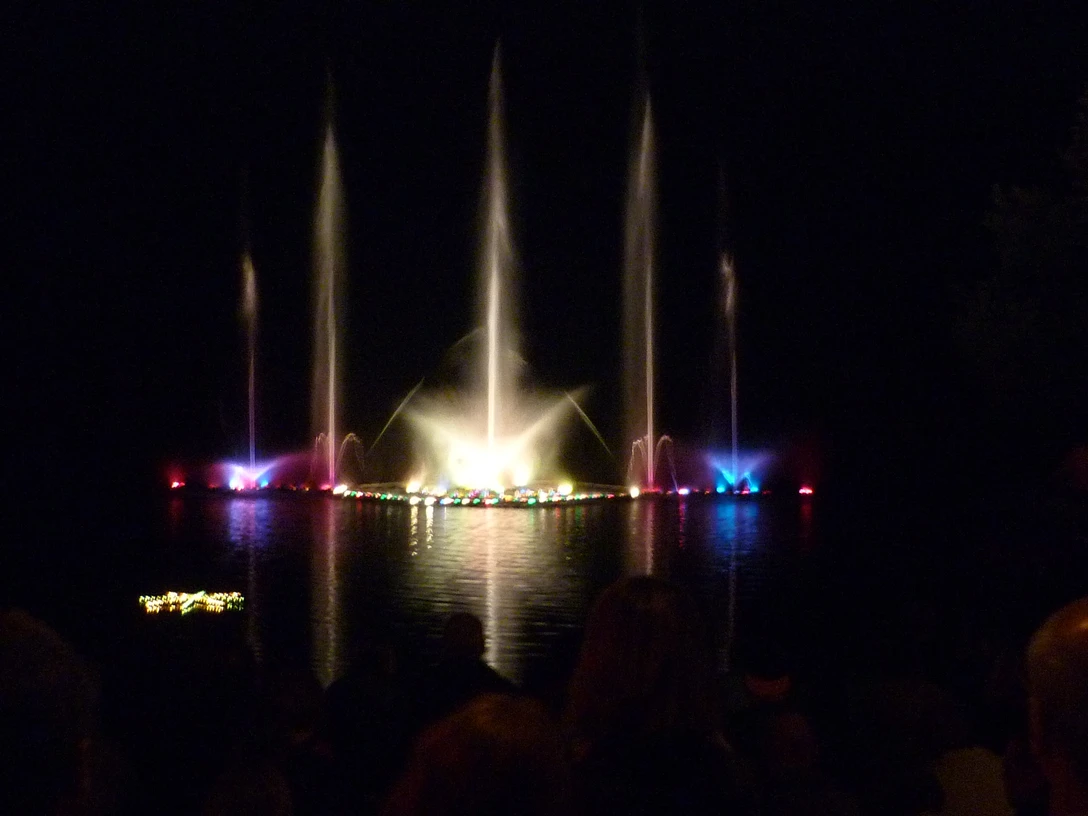 wasserspiele-seefest-behringen Farbig beleuchtete Wasserfontänen steigen bei Nacht aus dem Brunausee vor staunenden Zuschauern auf.