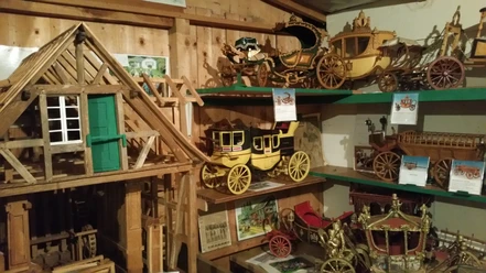Mühlenmuseum Odenthal Miniaturmodelle historischer Kutschen und ein Fachwerkhaus aus Holz in einem rustikalen Raum.