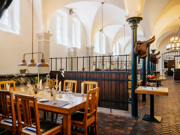 Innenansicht des Restaurant Pferdestall mit fein gedecktem Tisch.