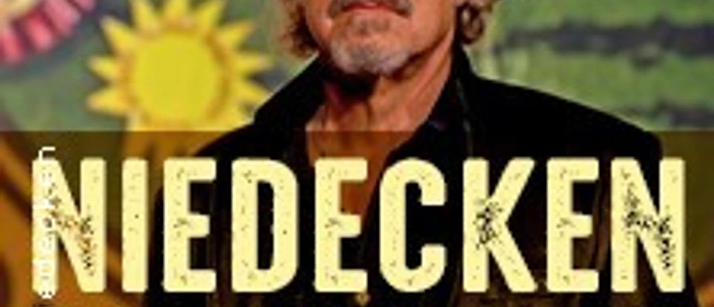 Sänger Wolfgang Niedecken in Sonnenbrille und Hut vor farbenfrohem Hintergrund mit Sonnendesign.