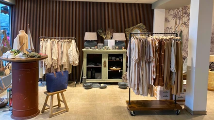mooi Ecke in einem Geschäft, Kleiderstangen, Vitrine mit Lampen Geschirr und Dekoartikeln