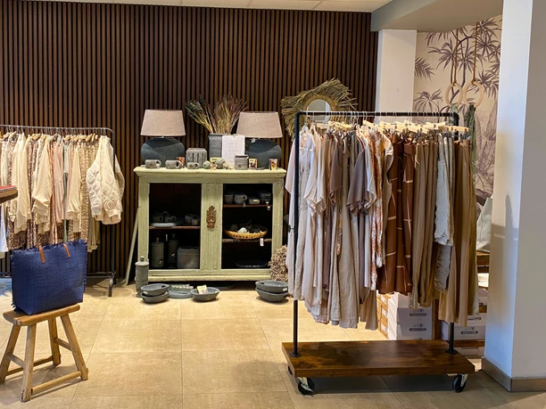 mooi Ecke in einem Geschäft, Kleiderstangen, Vitrine mit Lampen Geschirr und Dekoartikeln