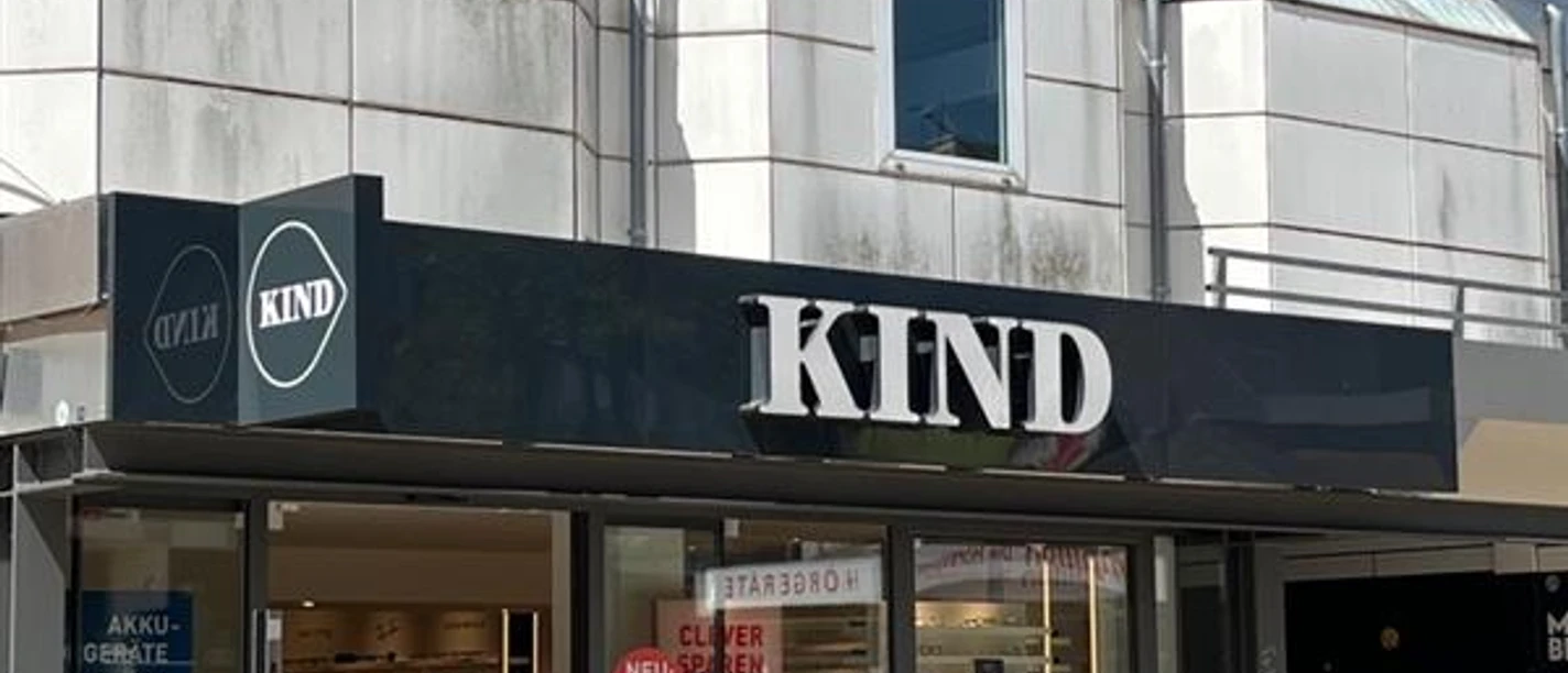 Kind Hörgeräte Kind-Hörgeräte-Filiale mit einladendem Eingangsbereich und klarer Fassadengestaltung.
