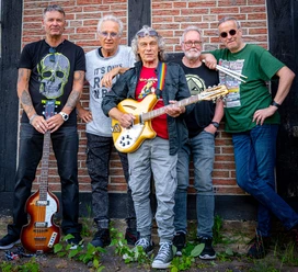 Lars-and-Friends (3).jpg Fünf Musiker stehen vor einer Backsteinmauer, mit Gitarren und lässiger Freizeitkleidung.