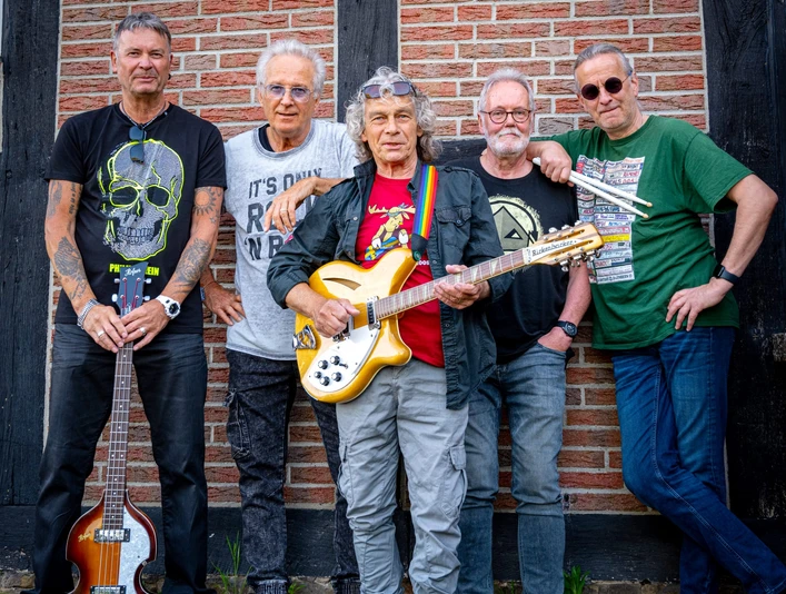 Lars-and-Friends (3).jpg Fünf Musiker stehen vor einer Backsteinmauer, mit Gitarren und lässiger Freizeitkleidung.