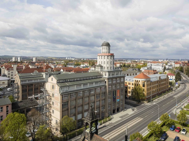 Außenansicht Historisches Gebäude in urbaner Umgebung mit belebter Straße und bewölktem Himmel.