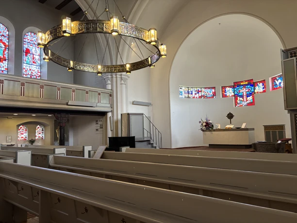 Kirche St. Nicolai in Westerland mit Sitzbänken und bunten Fenstern