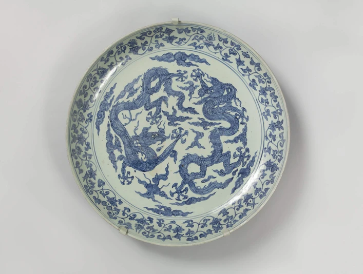 Large dragon shell Schale aus Porzellan mit blauen Drachenmotiven auf hellem Hintergrund.Porcelain bowl with blue dragon motifs on a light-coloured background.