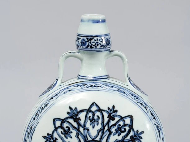 Moon bottle An artfully decorated porcelain bottle with round shapes and blue floral patterns on a white background.