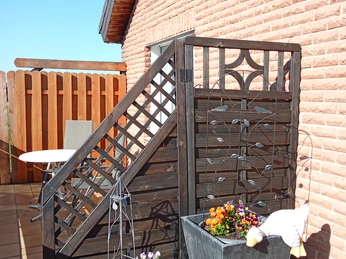 mit Holztrennwand zweigeteilter Balkon mit roter Backsteinfassade