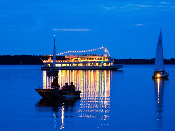 lichternacht-im-kurpark-abendfahrt-weisse-flotte Die Weiße Flotte gleitet im Abendlicht über das Zwischenahner Meer, begleitet von einem Segelboot.