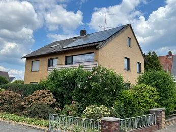 Ein zweigeschossiges Gebäude aus hellen Backsteinen mit Dachsolaranlagen und umgeben von üppigem Grün.A two-storey building made of light-colored bricks with solar panels on the roof and surrounded by lush greenery.En toetagers bygning lavet af lyse mursten med solpaneler på taget og omgivet af frodige grønne områder.Een gebouw van twee verdiepingen gemaakt van lichtgekleurde bakstenen met zonnepanelen op het dak en omgeven door weelderig groen.