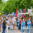 Lively street festival in Cologne, families enjoy colorful stalls and a cheerful atmosphere.