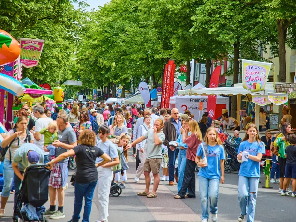 Lindenthaler-Familien-und-Veedelsfest_Krzysztof-Swider _S3-3238.jpg Lebhaftes Straßenfest in Köln, Familien genießen bunte Stände und fröhliche Atmosphäre.