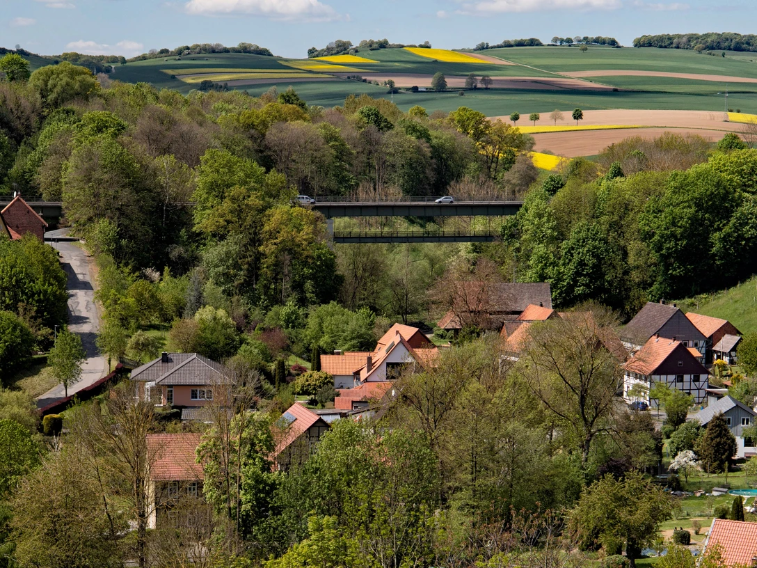 Blick ins Tal, Talbrücke Kuventhal Blick über Kuventhal mit der Talbrücke, umgeben von Feldern, Wäldern und roten Hausdächern.