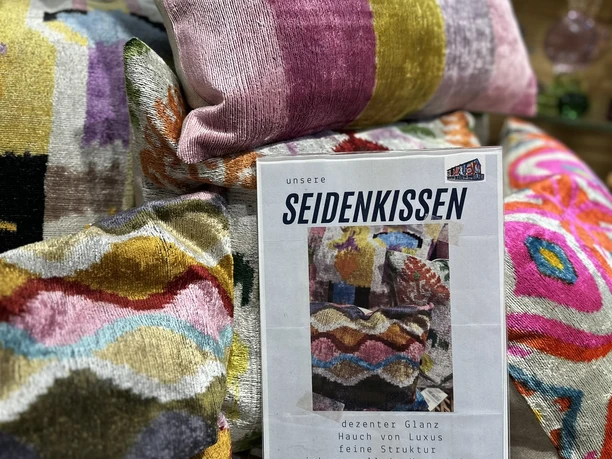 Bunte Seidenkissen schön auf einen kleinen Tisch drapiert.