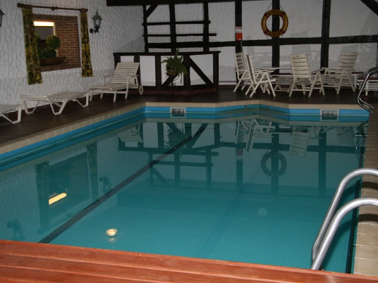 Hallenbad des Hotels Stadt Bremen Hallenbad im Hotel, umgeben von Sonnenliegen und Holzwänden, lädt zum Entspannen und Schwimmen ein.