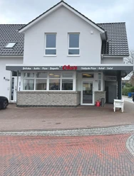 Aussenansicht Oba's Das Bild zeigt einen modernen Dönerladen mit einem hellen, weißen Außenanstrich. Über der Eingangstür prangt ein Schild mit der Aufschrift "Obas's".