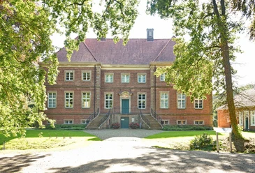 Gut Altenkamp.JPG Backsteingebäude mit barocker Fassade, breiter Freitreppe und gepflegtem Garten im Vordergrund