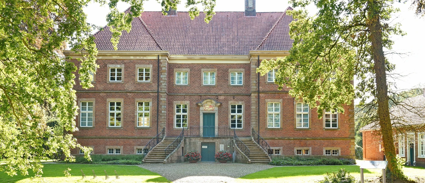 Gut Altenkamp.JPG Backsteingebäude mit barocker Fassade, breiter Freitreppe und gepflegtem Garten im Vordergrund
