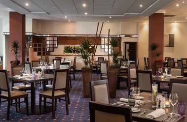 Innenraum im Restaurant Brasserie, Mettmann Der Innenraum eines stilvoll eingerichteten Restaurants mit gedeckten Tischen und warmem Licht.