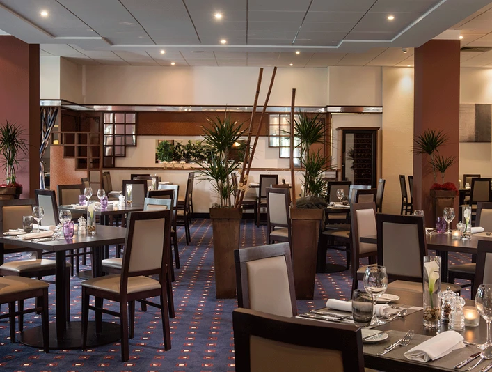 Innenraum im Restaurant Brasserie, Mettmann Der Innenraum eines stilvoll eingerichteten Restaurants mit gedeckten Tischen und warmem Licht.