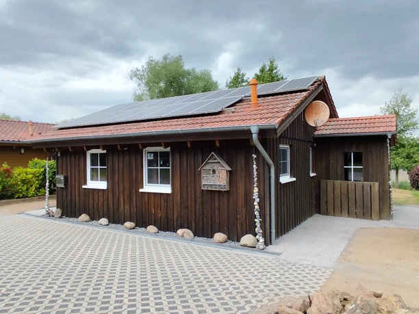 Außenansicht Ferienhaus Oelker Holzverkleidetes Haus, Solarpanelen auf dem Dach, Parkmöglichkeit am Haus