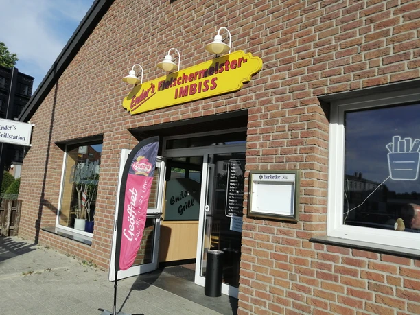 Enders Fleischerimbiss_Pro Herford (1).jpg Enders Fleischerimbiss mit offenem Eingang, drei Fassadenlampen und einer Coffeefair-Flagge außen.