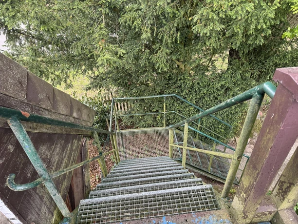 FeWo-Alscher-Amelinghuasen-2025 -außen (3).JPG Eine Feuertreppe führt durch dichtes Grün hinunter, umgeben von Bäumen.