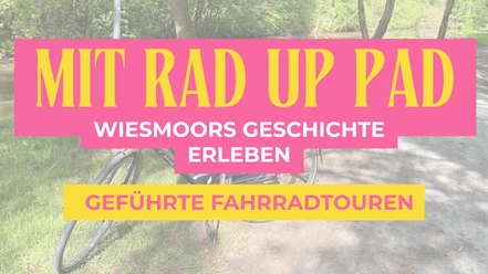 Destination.one (1920 x 1080 px) (2).png Zusehen ist schwach im Hintergrund ein Fahrrad und Bäume und ein Sand-weg, im Vordergrund steht in Orangener Schrift auf einem kräftigen Rosa Schild "Mit Rad up Pad" und darunter in weißer Schrift Wiesmoors Geschichte Erleben und darunter in Pinker Schrift auf orangenen Schild geschrieben "geführte Fahrradtour".