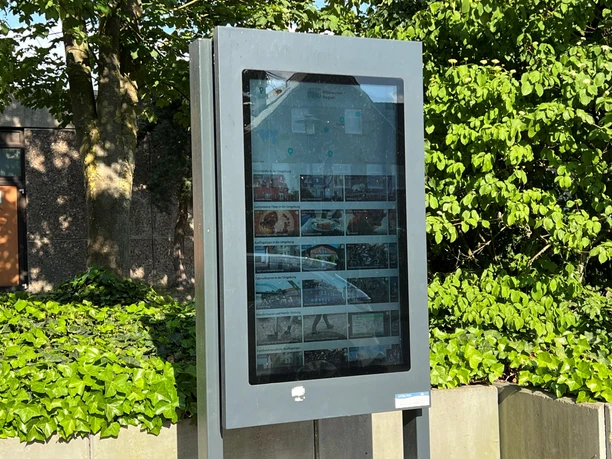 Outdoor information signs in Eystrup, surrounded by green foliage, provide up-to-date information for visitors.
