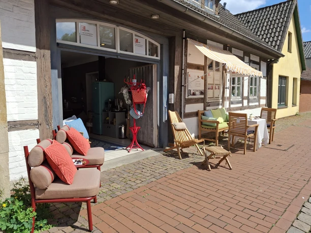 Café La Vie En Rose Traditionelles Café an einem gepflasterten Weg mit gemütlichen Sitzgelegenheiten und Sonnenschutz.