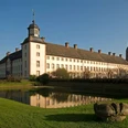 welterbe-corvey-gesamtanlage-kulturkreishoextercorveyggmbh Schloss Corvey mit seinen imposanten Türmen spiegelt sich im ruhigen Wassergraben wider.