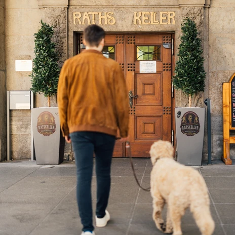 Ein Mann läuft mit seinem Hund zum Eingang des Ratskeller Leipzig im neuen RathausA man walks with his dog to the entrance of the Ratskeller Leipzig in the new town hallMuž jde se svým psem ke vchodu do Ratskeller Leipzig v nové radnici.Mężczyzna idzie z psem do wejścia do Ratskeller Leipzig w nowym ratuszu.Een man loopt met zijn hond naar de ingang van de Ratskeller Leipzig in het nieuwe stadhuisUn uomo cammina con il suo cane verso l'ingresso del Ratskeller di Lipsia nel nuovo municipio