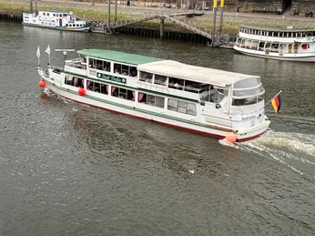 MS "Stadt Verden" Ein Ausflugsschiff mit Namen MS "Stadt Verden" fährt auf einem breiten Fluss bei bewölktem Himmel.