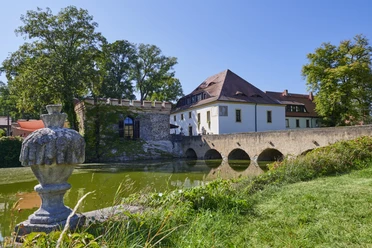 Schlosspark Lampertswalde Die Besucher können sich über das Wasserschloss Lampertswalde mit Wassergraben, Steinbrücke und üppigem Grün an einem klaren, sonnigen Tag freuen.