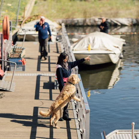 Eine Frau steht mit ihrem Hund auf einem Steg der Bootsanlegestelle im Stadthafen Leipzig und blickt gemeinsam mit ihm auf das WasserA woman stands with her dog on a jetty at the boat landing stage in Leipzig city harbor and looks out over the water with himŽena stojí se svým psem na molu u přístaviště lodí v lipském přístavu a dívá se s ním na vodu.Kobieta stoi ze swoim psem na pomoście przy przystani dla łodzi w porcie w Lipsku i patrzy z nim na wodęEen vrouw staat met haar hond op een steiger bij de aanlegsteiger voor boten in de stadshaven van Leipzig en kijkt met hem uit over het waterUna donna si trova con il suo cane su un pontile all'imbarcadero del porto di Lipsia e guarda l'acqua insieme a lui