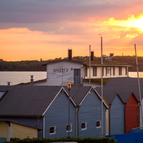 Die Sonne geht über dem Café und der Konditorei Kandler am Pier 1 im Hafen des Cospudener Sees im Leipziger Neuseenland unter und taucht den Himmel in rosa-gelbes LichtThe sun sets over the Kandler café and patisserie on Pier 1 in the harbor of Lake Cospuden in Leipzig's Neuseenland region, bathing the sky in pinkish-yellow lightSlunce zapadá nad kavárnou a cukrárnou Kandler na molu č. 1 v přístavu jezera Cospuden v lipské oblasti Neuseenland a zalévá oblohu růžovožlutým světlem.Słońce zachodzi nad kawiarnią i cukiernią Kandler na molo 1 w porcie nad jeziorem Cospuden w regionie Neuseenland w Lipsku, kąpiąc niebo w różowo-żółtym świetleDe zon gaat onder boven café en patisserie Kandler op Pier 1 in de haven van het Cospudenmeer in het Neuseenland in Leipzig en baadt de hemel in rozegeel licht.Il sole tramonta sul caffè e pasticceria Kandler, al molo 1 del porto del lago Cospuden, nella regione Neuseenland di Lipsia, inondando il cielo di una luce giallo-rosa.