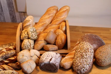 Brot und Brötchen Frisch gebackene Brote und Brötchen aus regionaler Bäckerkunst auf rustikalem Holztisch arrangiert.