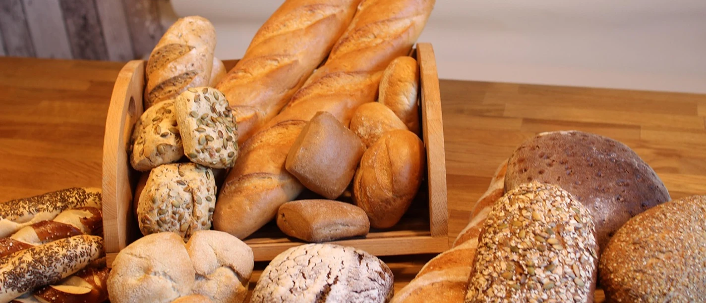 Brot und Brötchen Frisch gebackene Brote und Brötchen aus regionaler Bäckerkunst auf rustikalem Holztisch arrangiert.