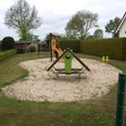 Spielplatz Holunderweg in Lübbecke Kleiner Spielplatz mit Kletterstruktur und Sandfläche, umgeben von Hecken und Häusern in ruhiger Lage.
