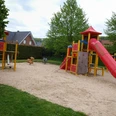 Spielplatz Am Wittelsbach in Lübbecke Spielplatz in Lübbecke mit Klettergerüst, Rutsche und Schaukeltieren auf Sandboden.